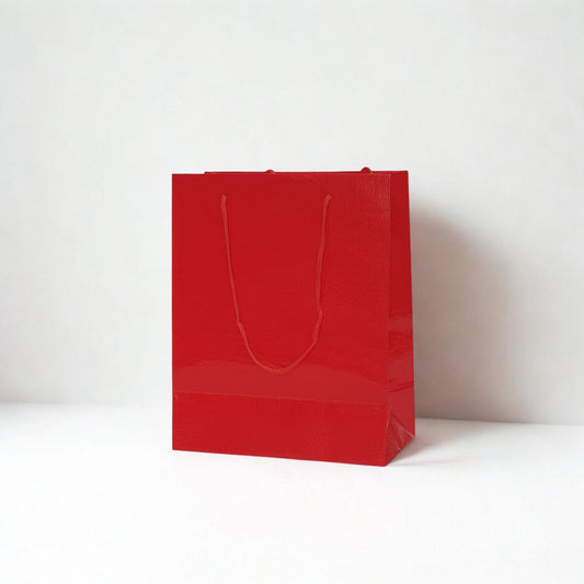 Small red glossy paper gift bag with matching rope handles for gifts and special occasions